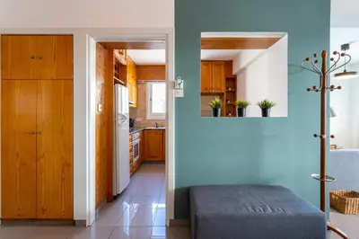 a kitchen with blue walls and wooden cabinets at Jayde 2-Bedroom Apartment in Larnaca in Larnaka