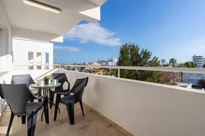 a balcony with black chairs and a table on a white railing at Jayde 2-Bedroom Apartment in Larnaca in Larnaka