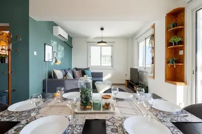 a dining room table with plates and glasses on it at Jayde 2-Bedroom Apartment in Larnaca in Larnaka