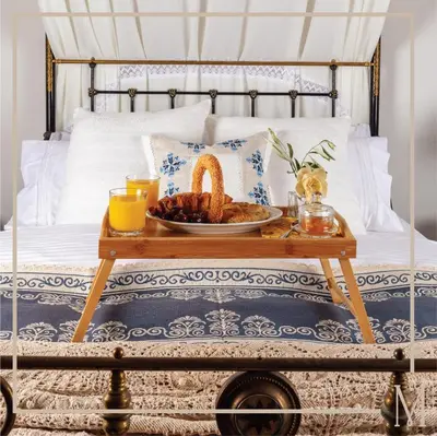 a tray of food on a table on a bed at Melissothea Stone Suites in Mesana