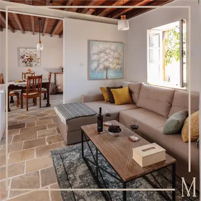 a living room with a couch and a table at Melissothea Stone Suites in Mesana