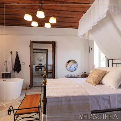 a bedroom with a bed and a bath tub at Melissothea Stone Suites in Mesana