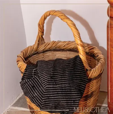 a wicker basket with a black and white bag at Melissothea Stone Suites in Mesana