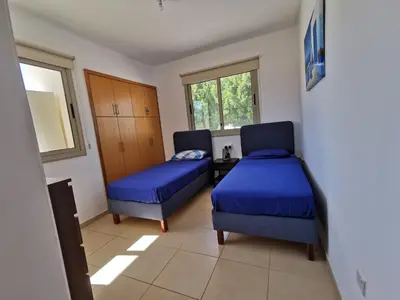 a room with two beds and a table and windows at Sunny coast apartment by the sea in Protaras