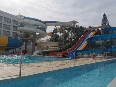a pool with a water park with a water slide at Sunny coast apartment by the sea in Protaras
