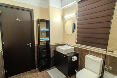 a bathroom with a toilet and a sink and a mirror at Elegant & Central Two Bedroom Flat in Larnaka