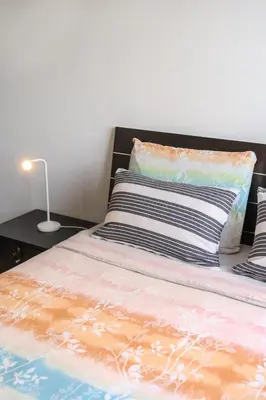 a bed with a pillow and a lamp on a table at Elegant & Central Two Bedroom Flat in Larnaka