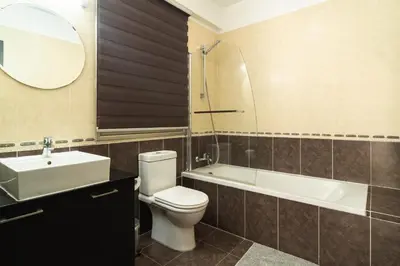 a bathroom with a toilet and a sink and a tub at Elegant & Central Two Bedroom Flat in Larnaka