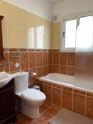 a bathroom with a toilet and a tub and a sink at Villa Rhea in Ayia Napa
