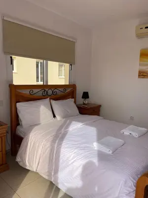 a large white bed with two white towels on it at Villa Rhea in Ayia Napa