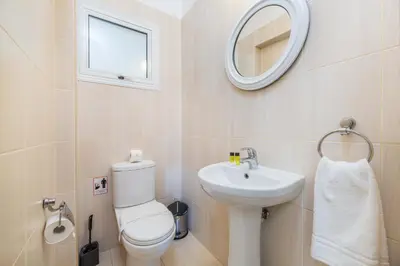 a bathroom with a toilet and a sink and a mirror at Estelle Suite in Ayia Napa