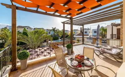 a patio with a table and chairs on a balcony at Villa Anna Maria in Ayia Napa