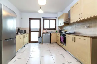 a large kitchen with wooden cabinets and stainless steel appliances at Villa Anna Maria in Ayia Napa