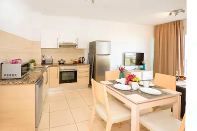 a kitchen and dining room with a table and chairs at Austin - Coralli Beachfront Apartment in Protaras