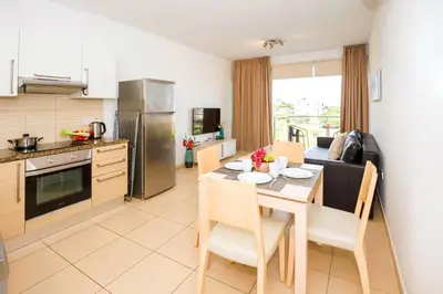 a kitchen and dining room with a table and chairs at Austin - Coralli Beachfront Apartment in Protaras