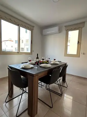 a dining room table with chairs and wine glasses at DAFNI VILLA BY PANN in Protaras