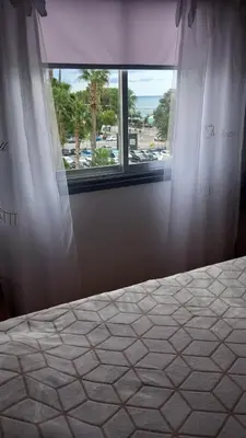 a bedroom with a bed and a large window at Sea view in Limassol