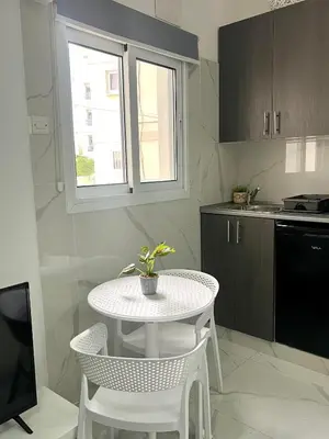 a small kitchen with a white table and chairs at Nicolas 1 in Larnaka