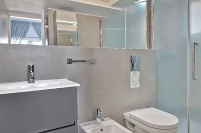 a bathroom with a toilet and a sink and a mirror at Phaedrus Living: Beach Front Flat Kyma in Limassol