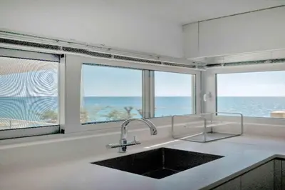 a kitchen with a sink and a view of the ocean at Phaedrus Living: Beach Front Flat Kyma in Limassol