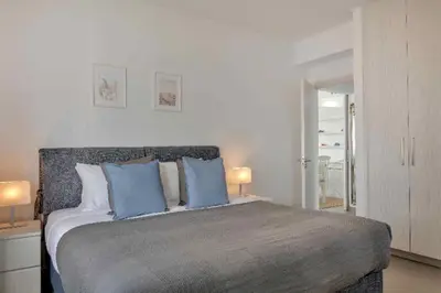 a bedroom with a large bed with blue pillows at Phaedrus Living: Beach Front Flat Kyma in Limassol