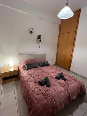 a bedroom with a bed with two black shoes on it at Makenzie 2 rooms first line beach in Larnaka
