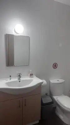 a bathroom with a sink and a toilet and a mirror at Lovely studio in Makedonitissa in Nicosia