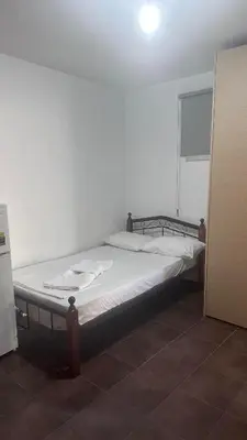 a large bed in a room with a white wall at Lovely studio in Makedonitissa in Nicosia