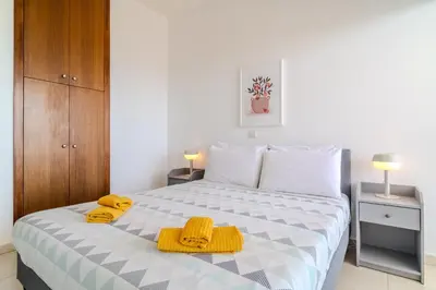 a bedroom with a bed with yellow towels on it at Amazing Sea and Marina View City Center 2BDR Flat in Larnaka