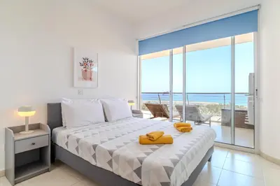 a bedroom with a bed with a view of the ocean at Amazing Sea and Marina View City Center 2BDR Flat in Larnaka