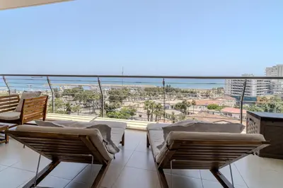 a balcony with chairs and a view of the ocean at Amazing Sea and Marina View City Center 2BDR Flat in Larnaka