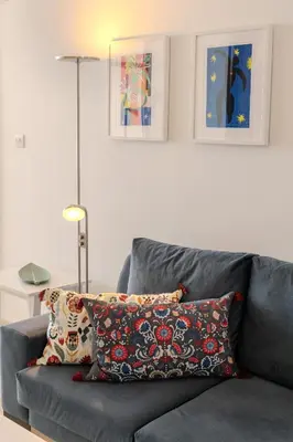 a gray couch with a pillow on it in a living room at Amazing Sea and Marina View City Center 2BDR Flat in Larnaka
