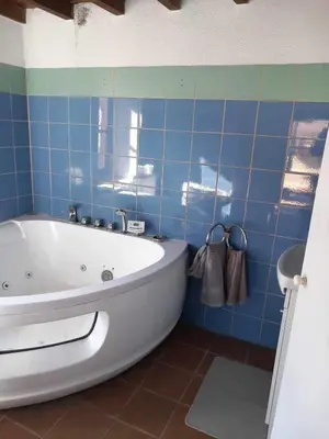 a blue tiled bathroom with a white bath tub at Πετροκτιστο in Kakopetria