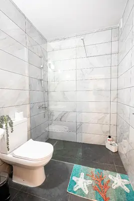 a bathroom with a white toilet and a shower at COZY Apartment In Kapparis #2 in Paralimni