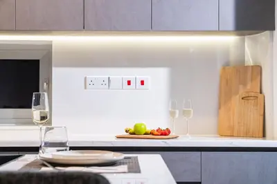 a kitchen with two wine glasses and a plate of fruit at Venus Apartment in Larnaka
