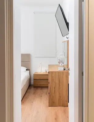 a bedroom with a bed and a desk with a tv at Venus Apartment in Larnaka