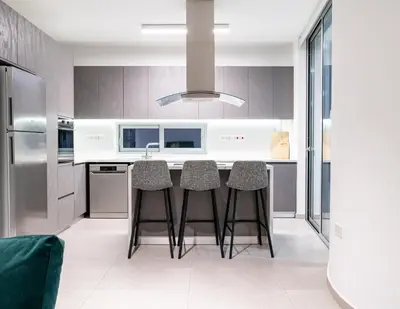 a kitchen with a island with bar stools at Venus Apartment in Larnaka