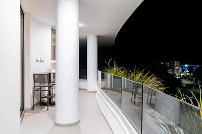 a balcony with views of the city at night at Venus Apartment in Larnaka