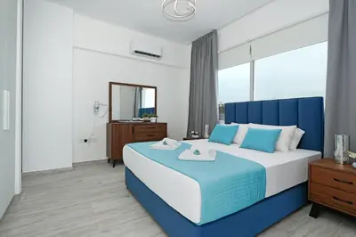 a bedroom with a blue and white bed and a mirror at Villa Napa Blu in Ayia Napa