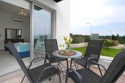 a patio with a table and chairs on a balcony at Villa Napa Blu in Ayia Napa