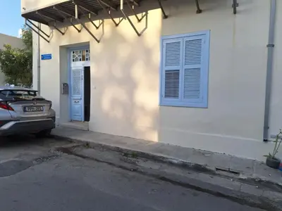 a car parked in front of a house with a blue door at Pavlos Place - Blue Haven in Limassol