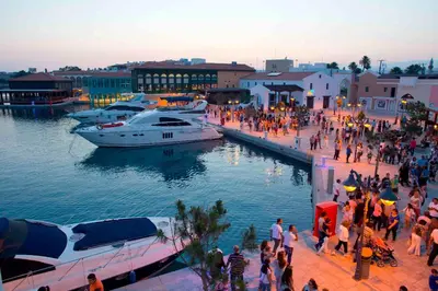 a group of people walking along a dock with boats at Pavlos Place - Blue Haven in Limassol