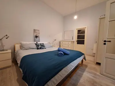 a bedroom with a large bed with a blue blanket at Pavlos Place - Blue Haven in Limassol