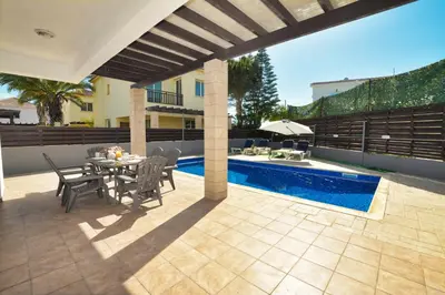 a patio with a table and chairs next to a pool at Villa Argyro in Ayia Napa