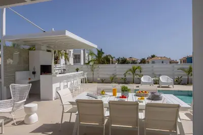 a patio with a table and chairs and a pool at SunnyVillas-3BR New Modern Villa-Private Pool-BLG in Paralimni