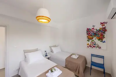 a bedroom with two beds and a painting on the wall at SunnyVillas-3BR New Modern Villa-Private Pool-BLG in Paralimni