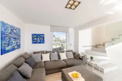 a living room with a couch and a table at Protaras Elaia Luxury Seafront Villa in Protaras