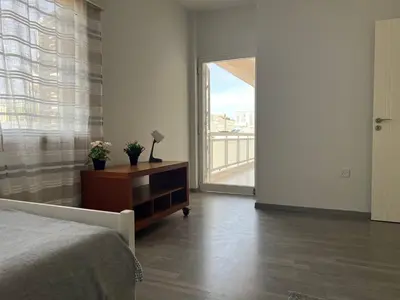a bedroom with a bed and a dresser and a window at Quiet place in Limassol