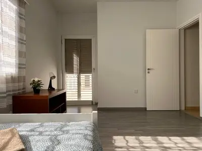 a bedroom with a bed and a table with a lamp at Quiet place in Limassol