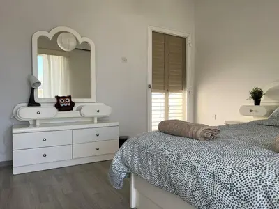 a bedroom with a bed and a dresser and a mirror at Quiet place in Limassol
